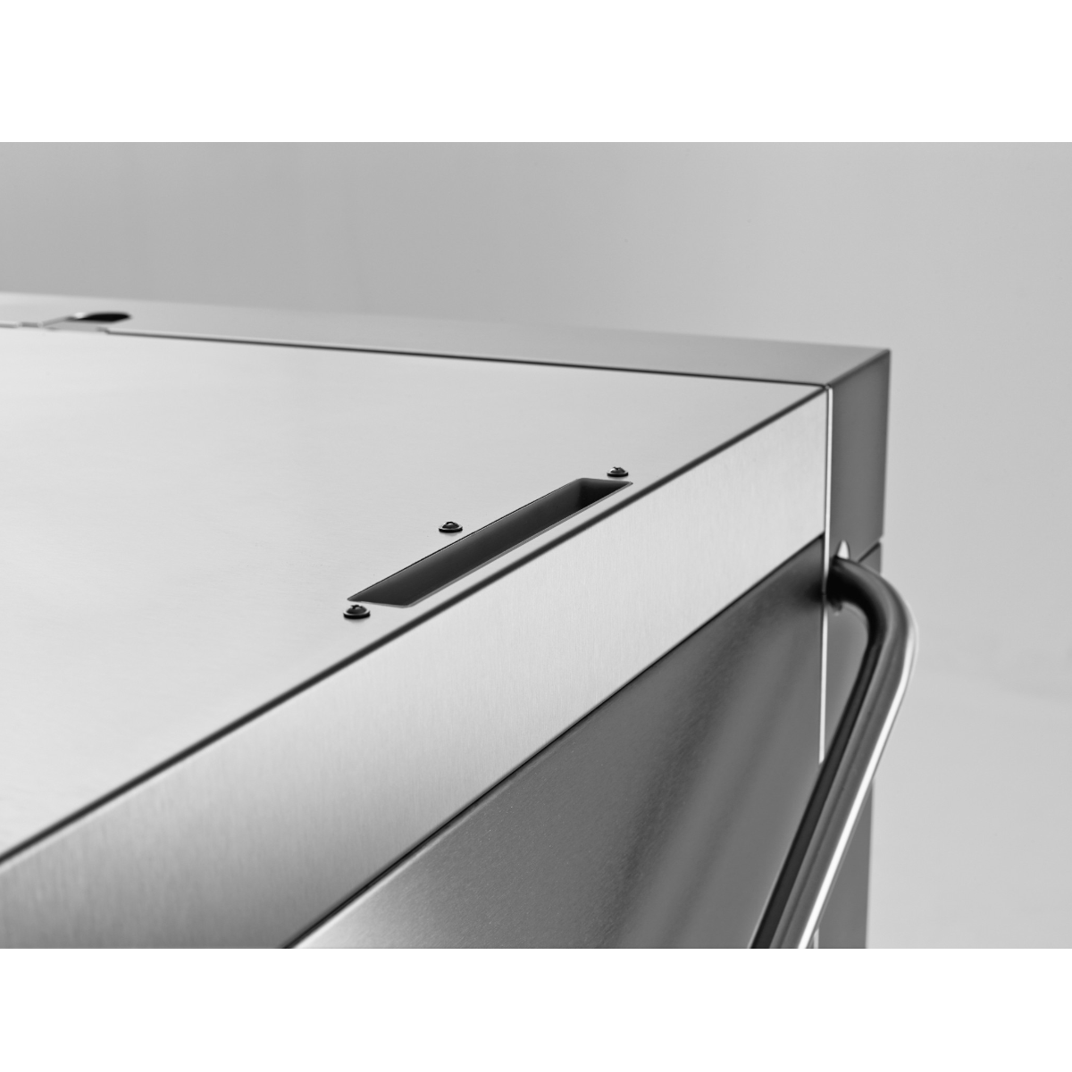 Close-up detail of Hobart Profi AMXT Double Rack Passthrough Glass & Dishwasher | Dishwashers Direct showing a brushed metal surface, a black handle recess, and a curved black handle 
